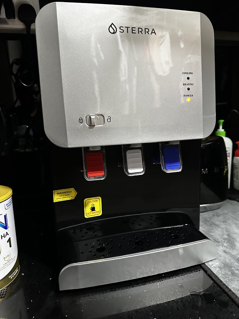 A close-up of a Sterra water dispenser with hot and cold water options.