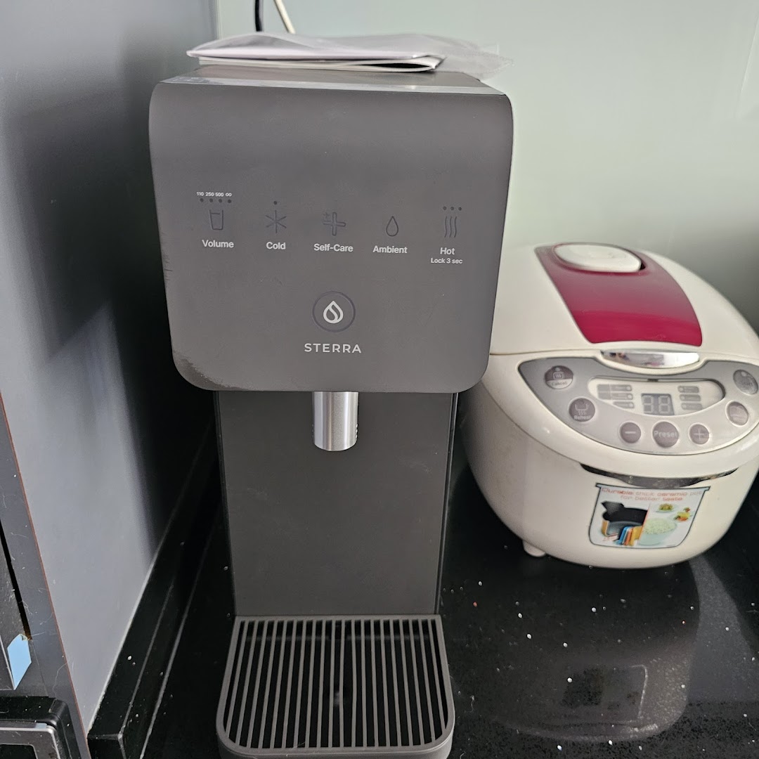 A Sterra water dispenser with a rice cooker on a kitchen counter, showcasing home appliances.