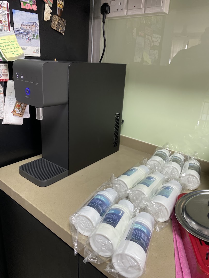 A modern Sterra water dispenser with multiple replacement filters on a kitchen counter.