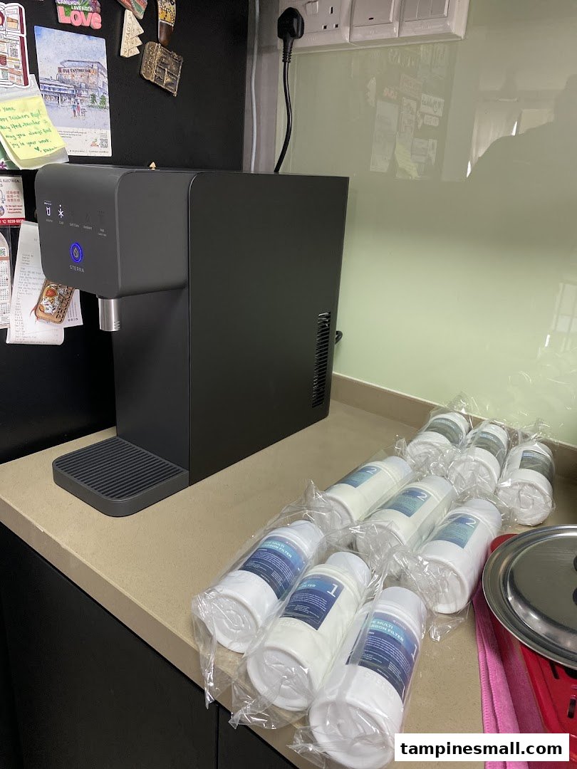 A modern Sterra water dispenser with multiple replacement filters on a kitchen counter.