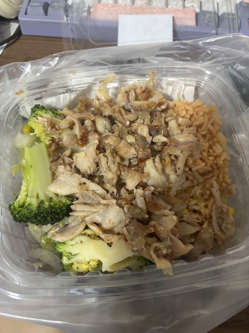 A close-up of a Stuffd meal bowl featuring shredded meat, rice, and broccoli in a clear plastic container.
