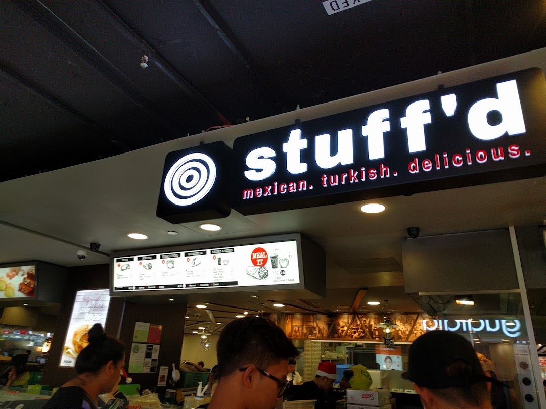 The illuminated 'Stuffd' sign with 'mexican. turkish. delicious.' tagline above a digital menu board and counter.