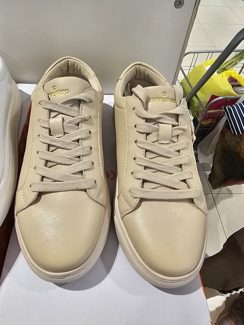 A close-up view of a pair of light-colored Sunnystep sneakers displayed in the store.