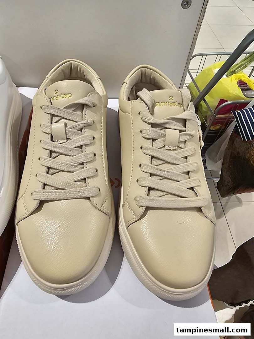 A close-up view of a pair of light-colored Sunnystep sneakers displayed in the store.