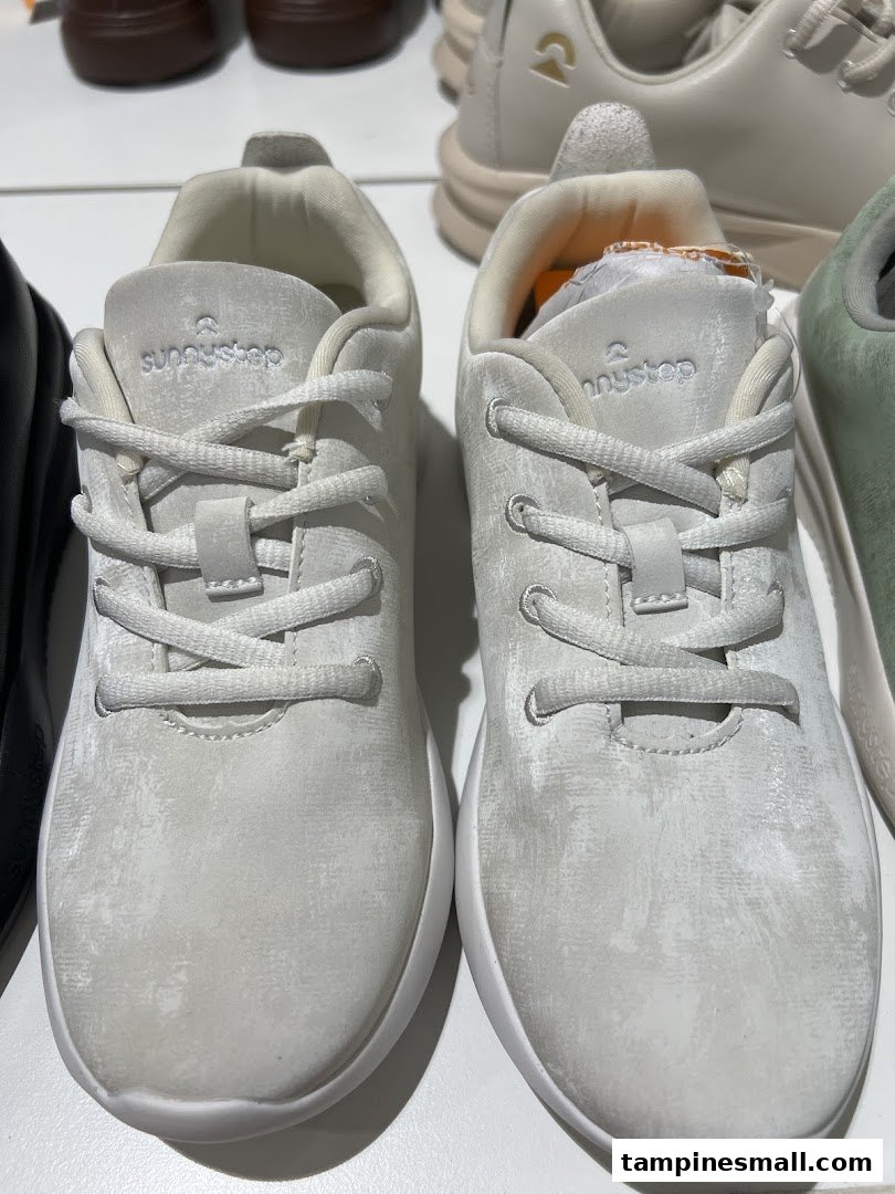 A close-up view of two pairs of light-colored Sunnystep sneakers on display.