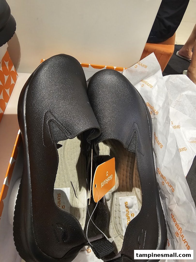 A new pair of black slip-on shoes from Sunnystep, still in their box with branding visible.