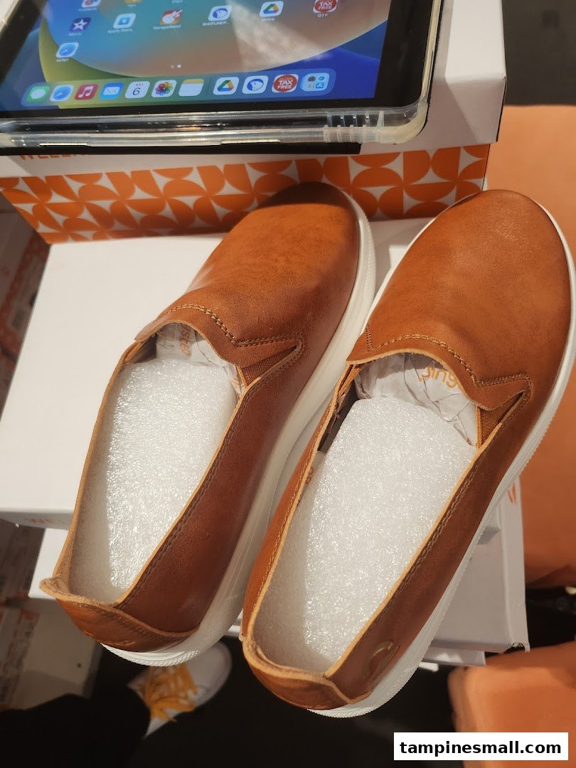 A pair of new brown slip-on shoes with white soles, displayed on a box, possibly a recent purchase.