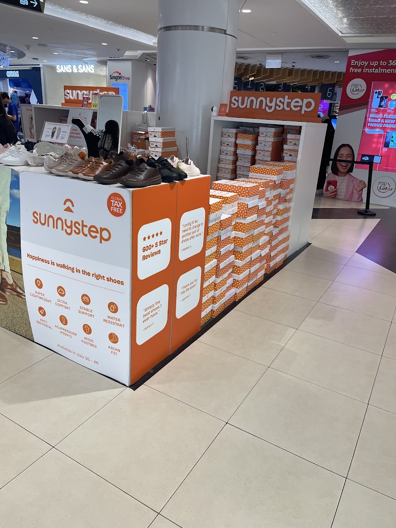 A Sunnystep retail display showcasing various comfortable shoes and brand features in a mall.