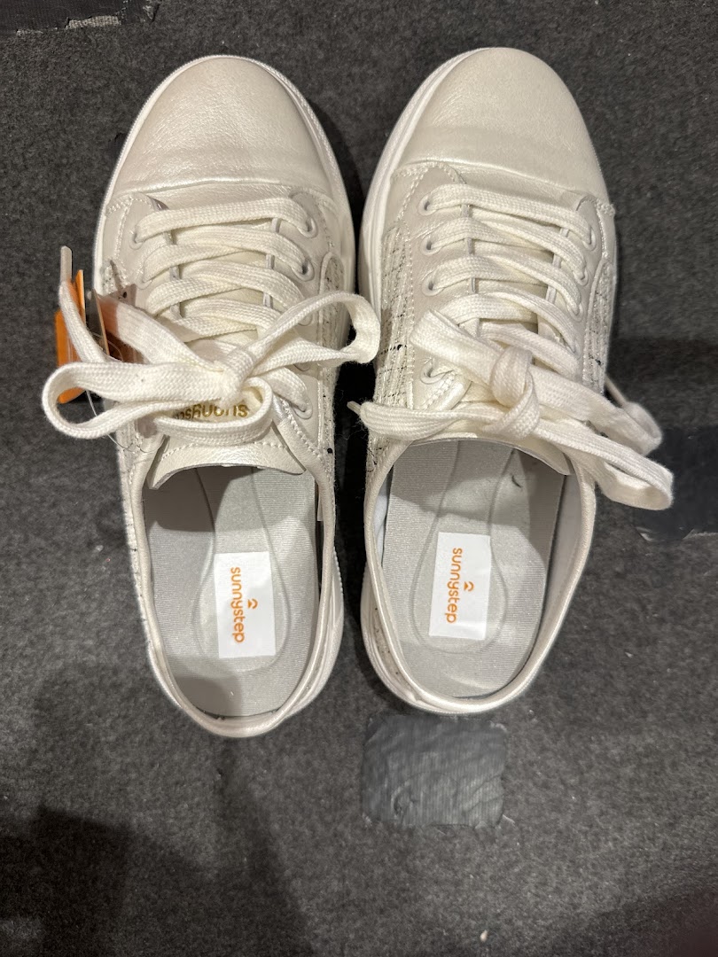 A top-down view of a pair of white Sunnystep sneakers with visible brand insoles.