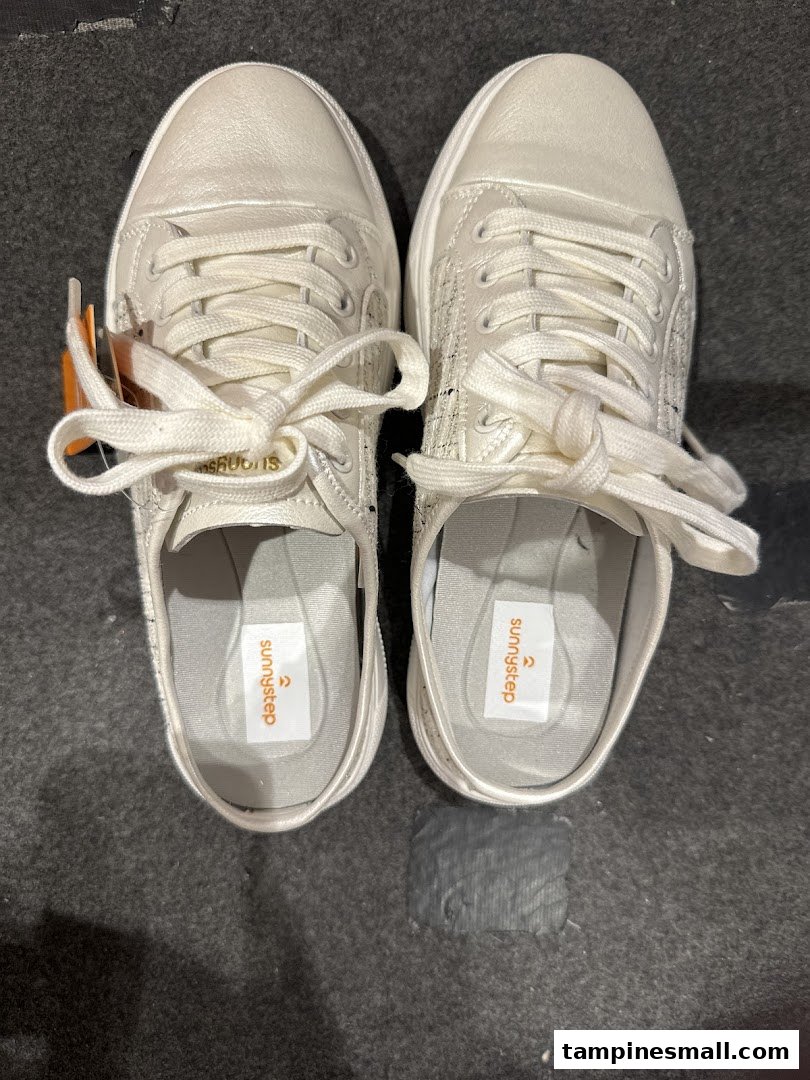 A top-down view of a pair of white Sunnystep sneakers with visible brand insoles.