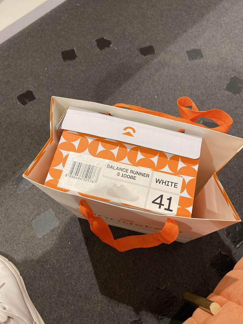 A Sunnystep shopping bag containing a shoebox for 'Balance Runner' shoes in white, size 41.