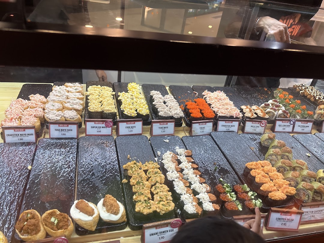 A vibrant display of various sushi and inari options with price tags at Super Sushi.