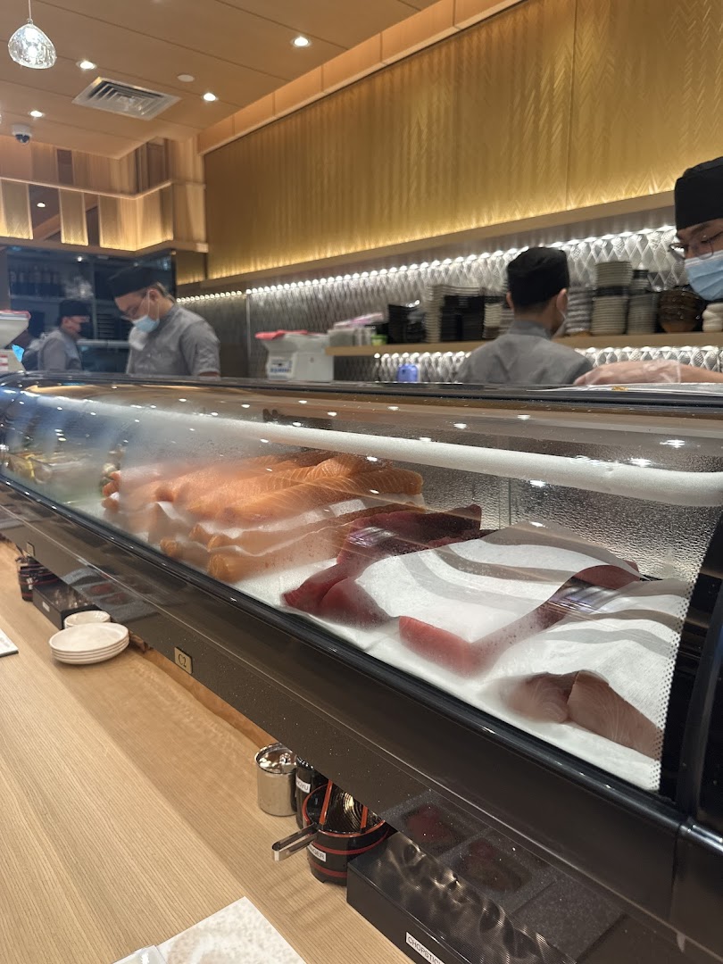 A vibrant view of the sushi counter at Sushi Zanmai, showcasing fresh fish and chefs at work.