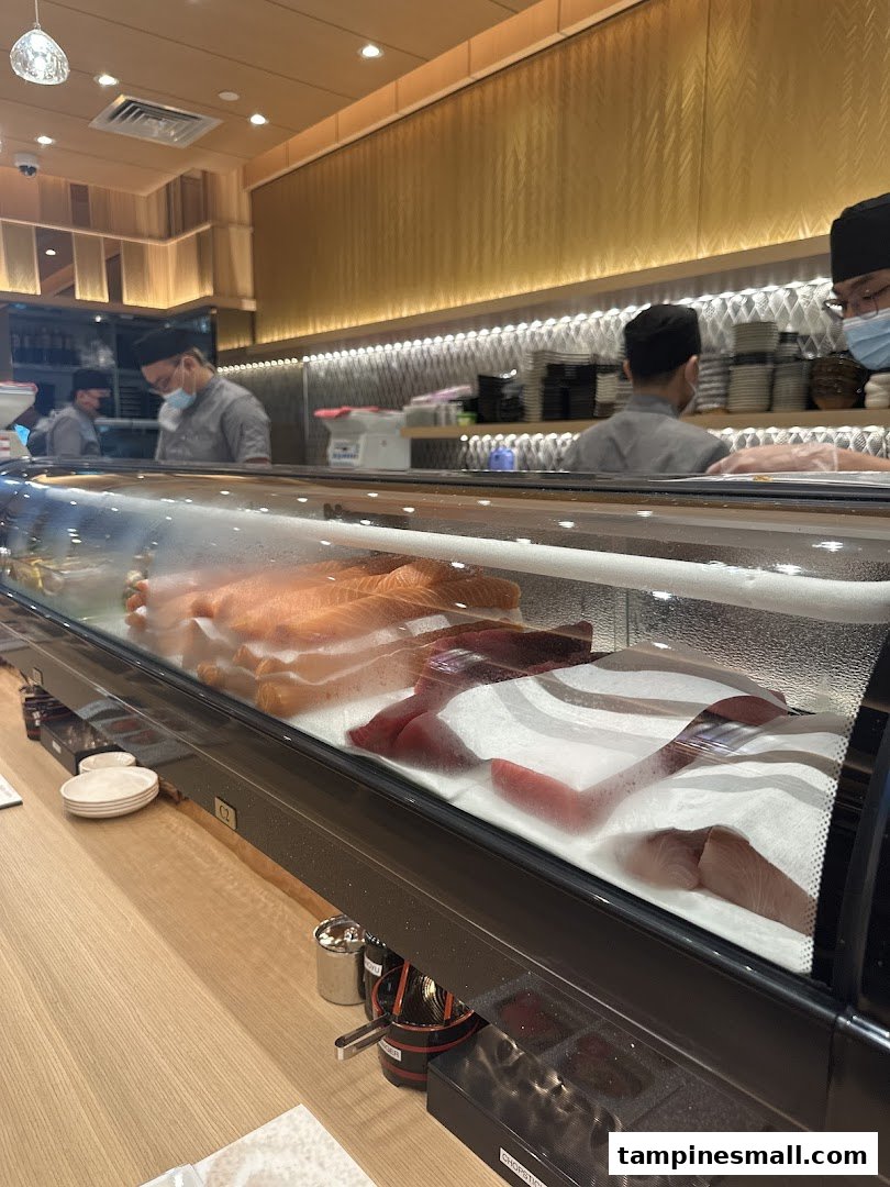 A vibrant view of the sushi counter at Sushi Zanmai, showcasing fresh fish and chefs at work.