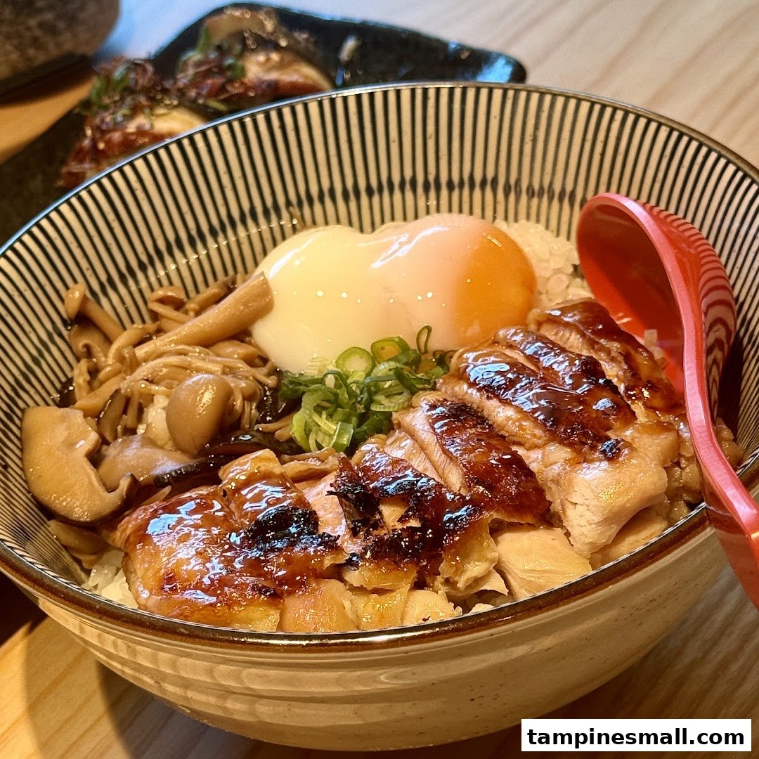A delicious Japanese rice bowl with grilled chicken, mushrooms, and a poached egg.