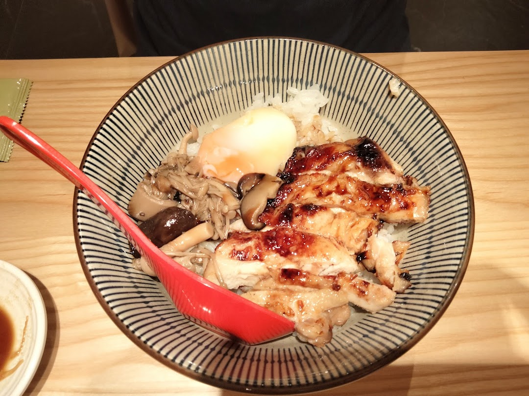 A delicious Japanese rice bowl featuring grilled chicken, assorted mushrooms, and a soft-boiled egg.