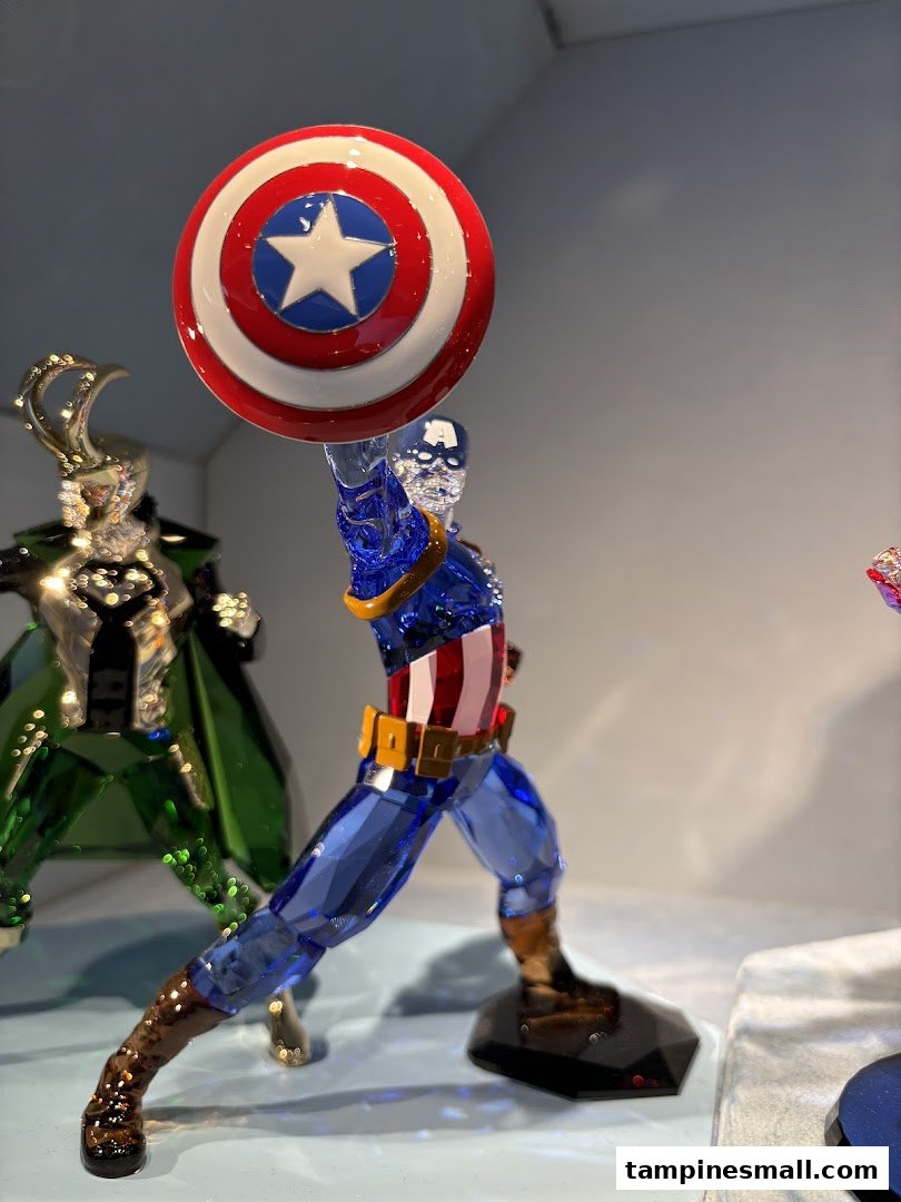 A detailed crystal figurine of Captain America with his shield, displayed in a Swarovski store.