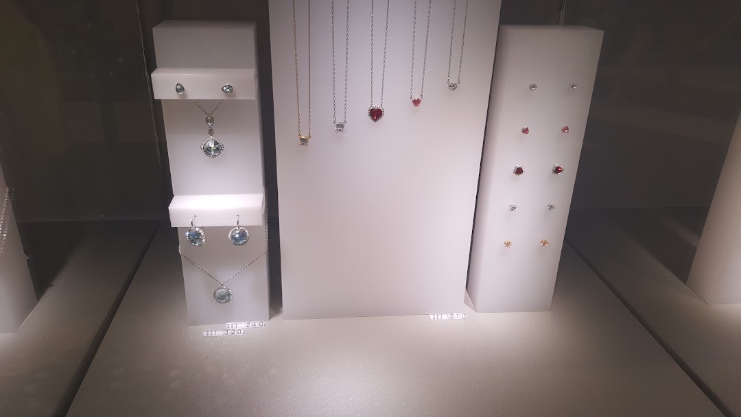 A display case showcasing various Swarovski crystal necklaces and earrings in different designs and colors.
