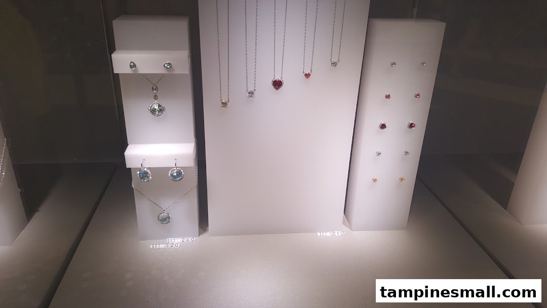 A display case showcasing various Swarovski crystal necklaces and earrings in different designs and colors.