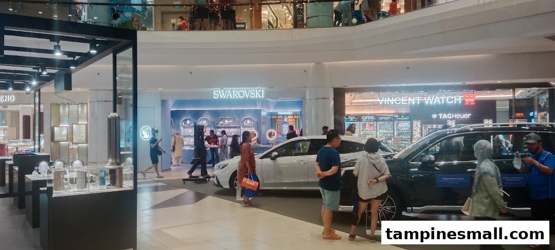 The brightly lit Swarovski storefront showcasing crystal displays, with shoppers and cars in the mall's common area.