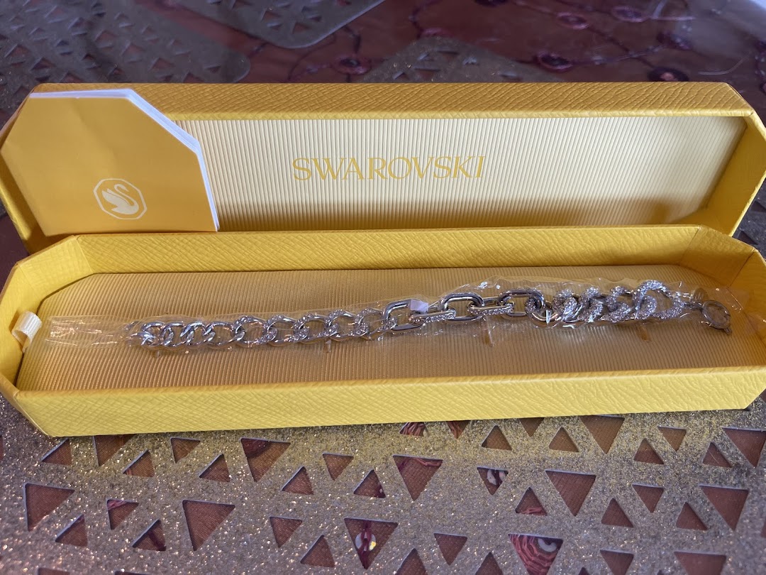 A sparkling Swarovski bracelet presented in its signature yellow gift box.