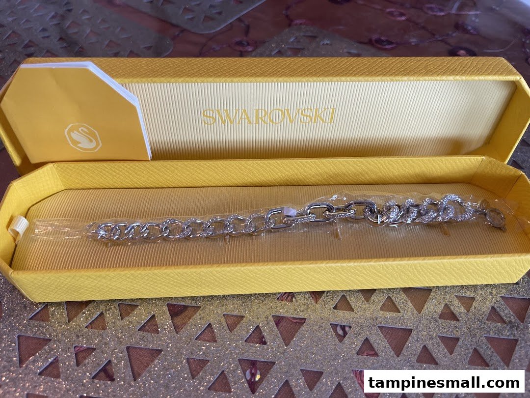 A sparkling Swarovski bracelet presented in its signature yellow gift box.