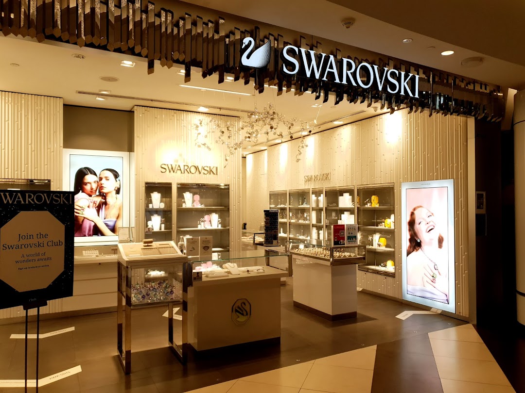 The brightly lit entrance of a Swarovski store showcasing sparkling crystal jewelry and accessories.