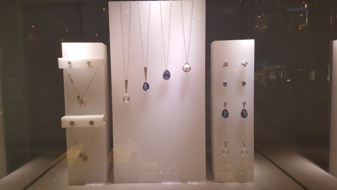 A close-up view of a Swarovski display case showcasing various necklaces and earrings with sparkling crystals.
