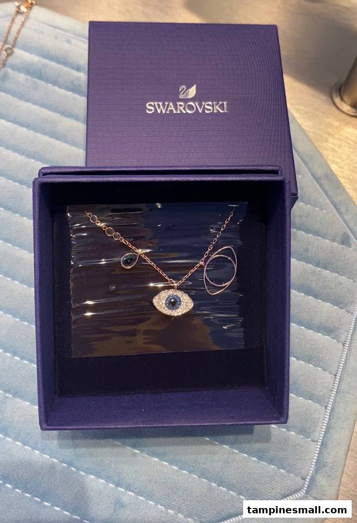 A rose gold-tone Swarovski necklace with an evil eye pendant in its signature blue box.