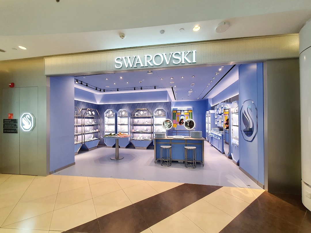 The elegant entrance of a Swarovski store showcasing its signature blue interior and sparkling displays.