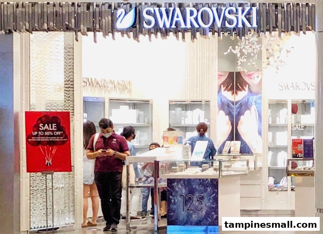 The entrance of Swarovski at Tampines Mall, featuring a sale sign and customers browsing sparkling jewelry.
