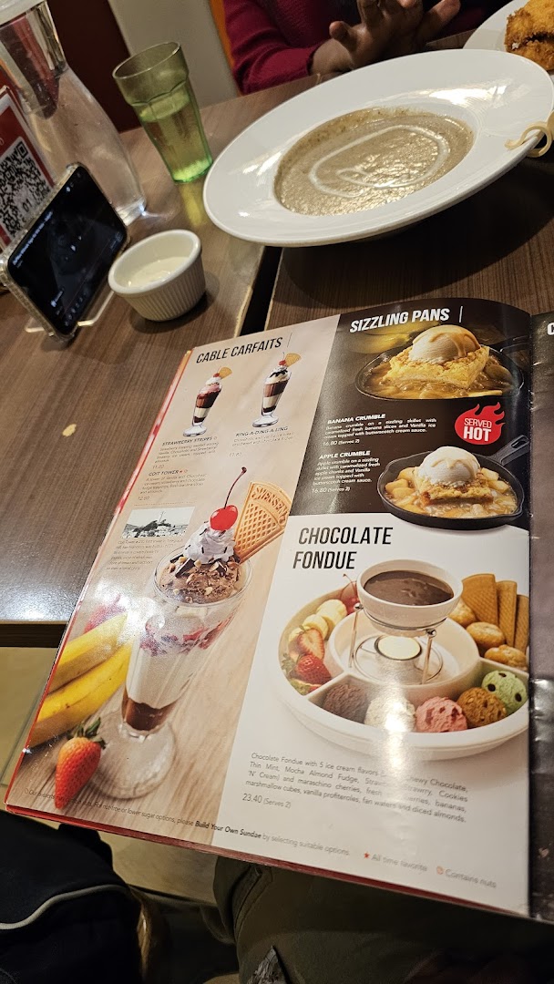 A close-up of Swensen's dessert menu featuring sundaes, sizzling pans, and chocolate fondue.