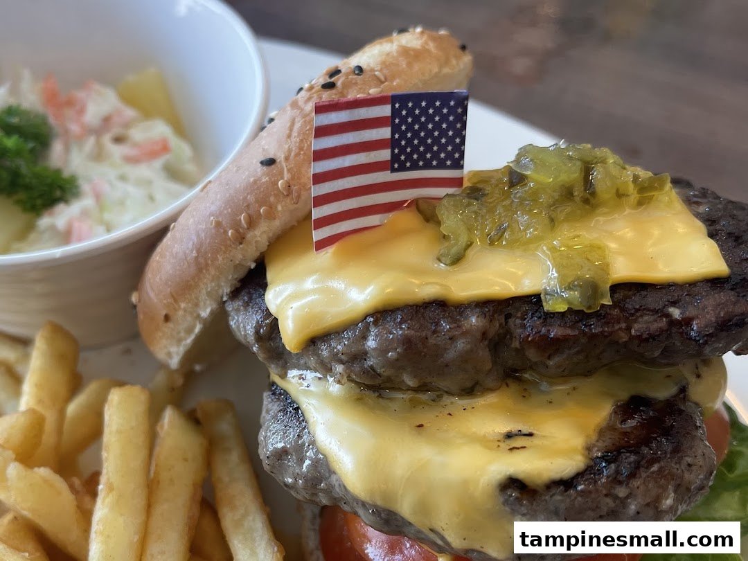 A delicious double cheeseburger with fries, coleslaw, and an American flag garnish.