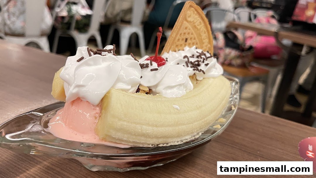 A delightful banana split dessert with whipped cream, sprinkles, and a cherry, served in a glass dish.