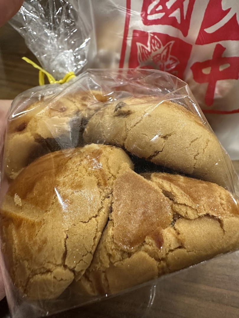 A close-up of traditional Chinese pastries, likely peanut cookies, packaged in a clear bag.
