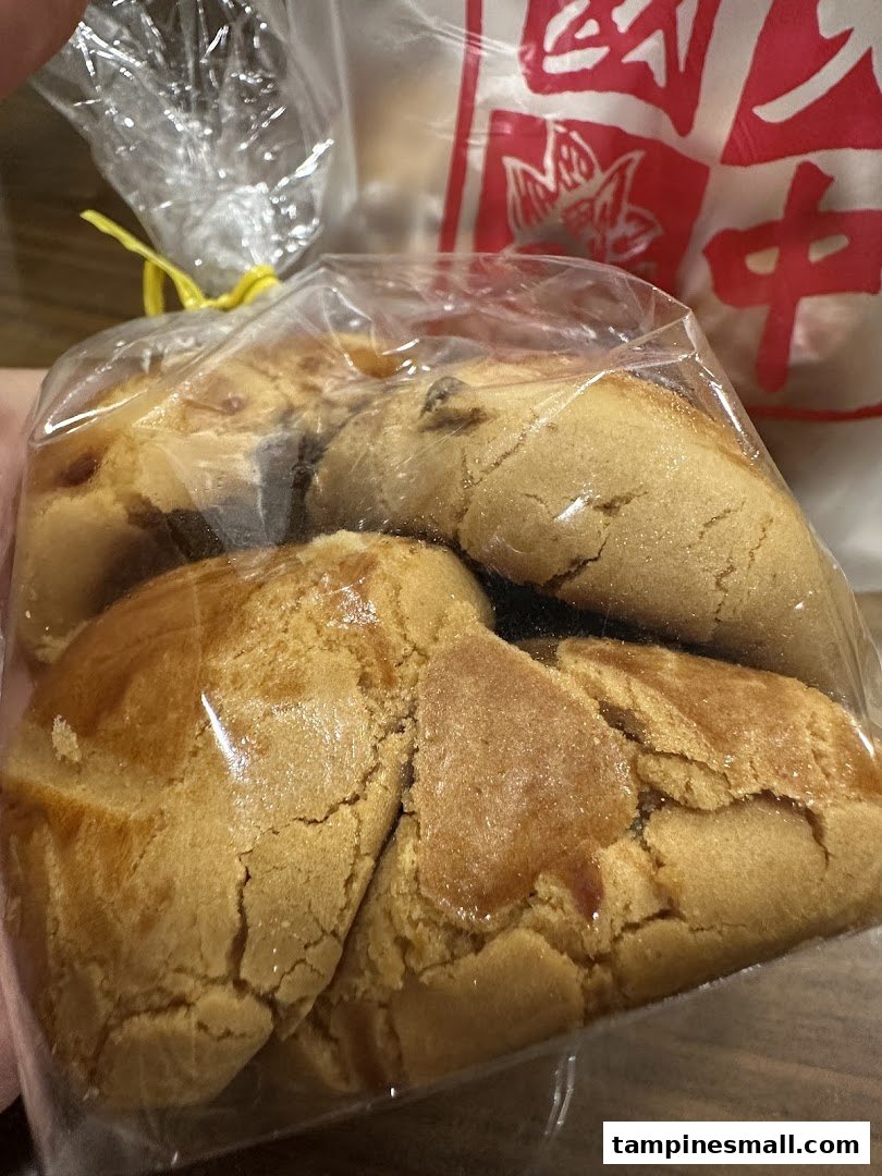 A close-up of traditional Chinese pastries, likely peanut cookies, packaged in a clear bag.