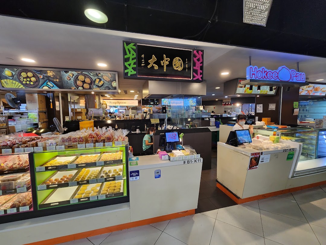 An interior view of Tai Chong Kok bakery, showcasing display cases filled with traditional pastries and packaged snacks.