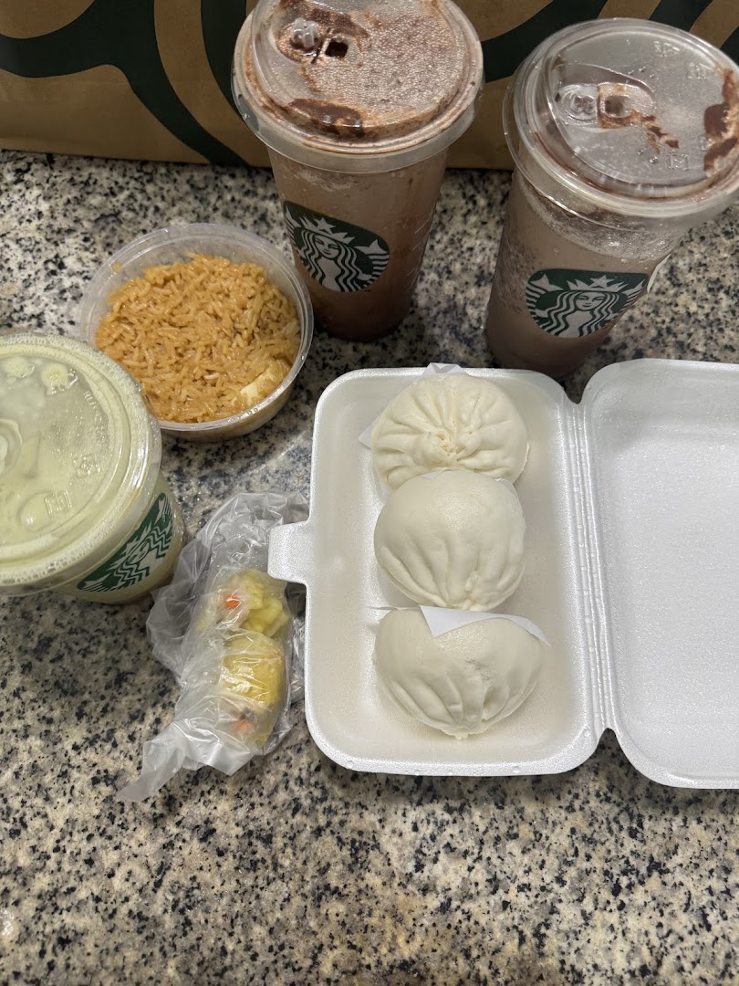 An assortment of steamed buns, rice, and drinks from Tanjong Rhu Pau on a countertop.