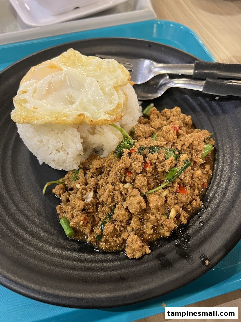 A delicious plate of Thai basil minced meat with rice and a perfectly fried egg.