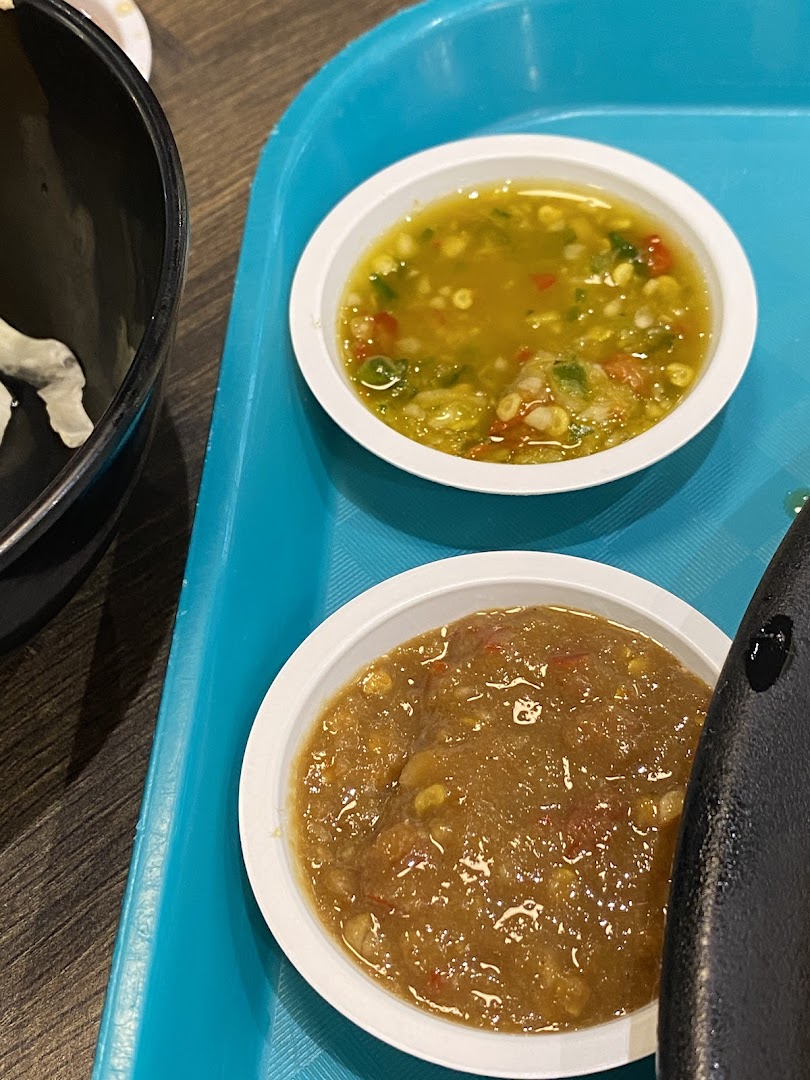 Two small bowls of flavorful Thai dipping sauces or condiments on a blue tray.