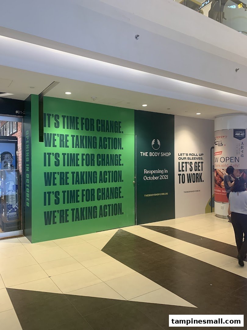 The Body Shop's vibrant green hoarding announces its reopening in October 2021, featuring motivational slogans.
