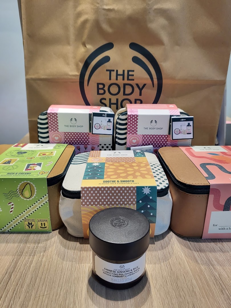 The image displays various skincare gift sets and a product from The Body Shop, with a branded shopping bag.
