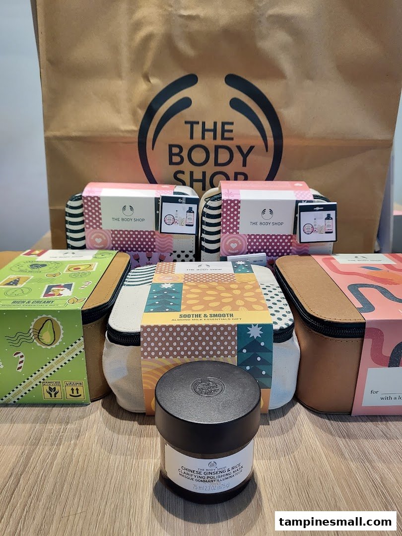 The image displays various skincare gift sets and a product from The Body Shop, with a branded shopping bag.
