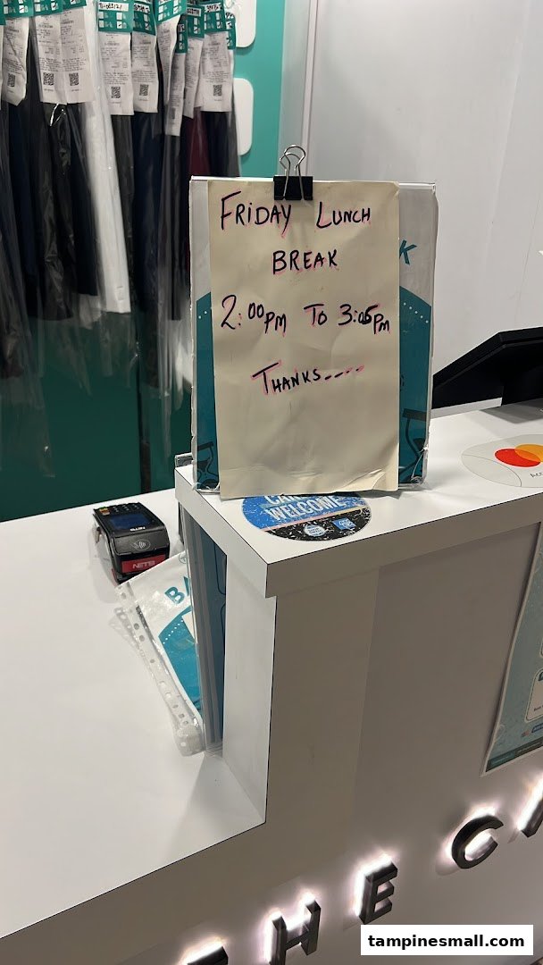 A counter at The Care Laundry with a sign indicating Friday lunch break hours and laundered items.