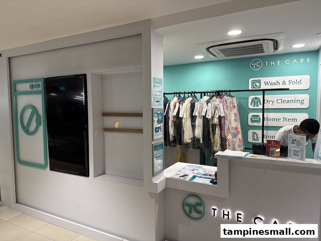 Interior view of The Care laundry service counter, showcasing various cleaning services and a staff member.