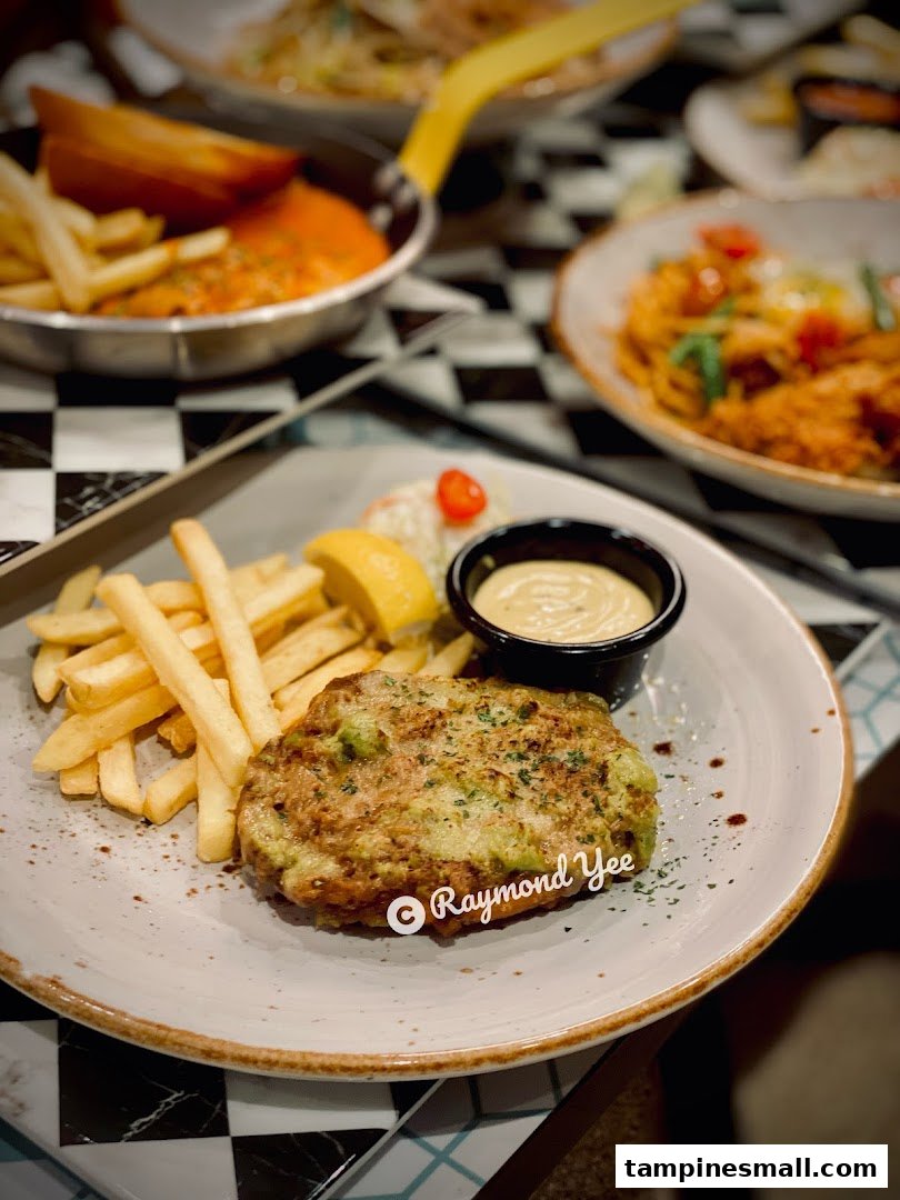 A close-up of a delicious meal featuring a savory patty, golden fries, and dipping sauce on a checkered table.