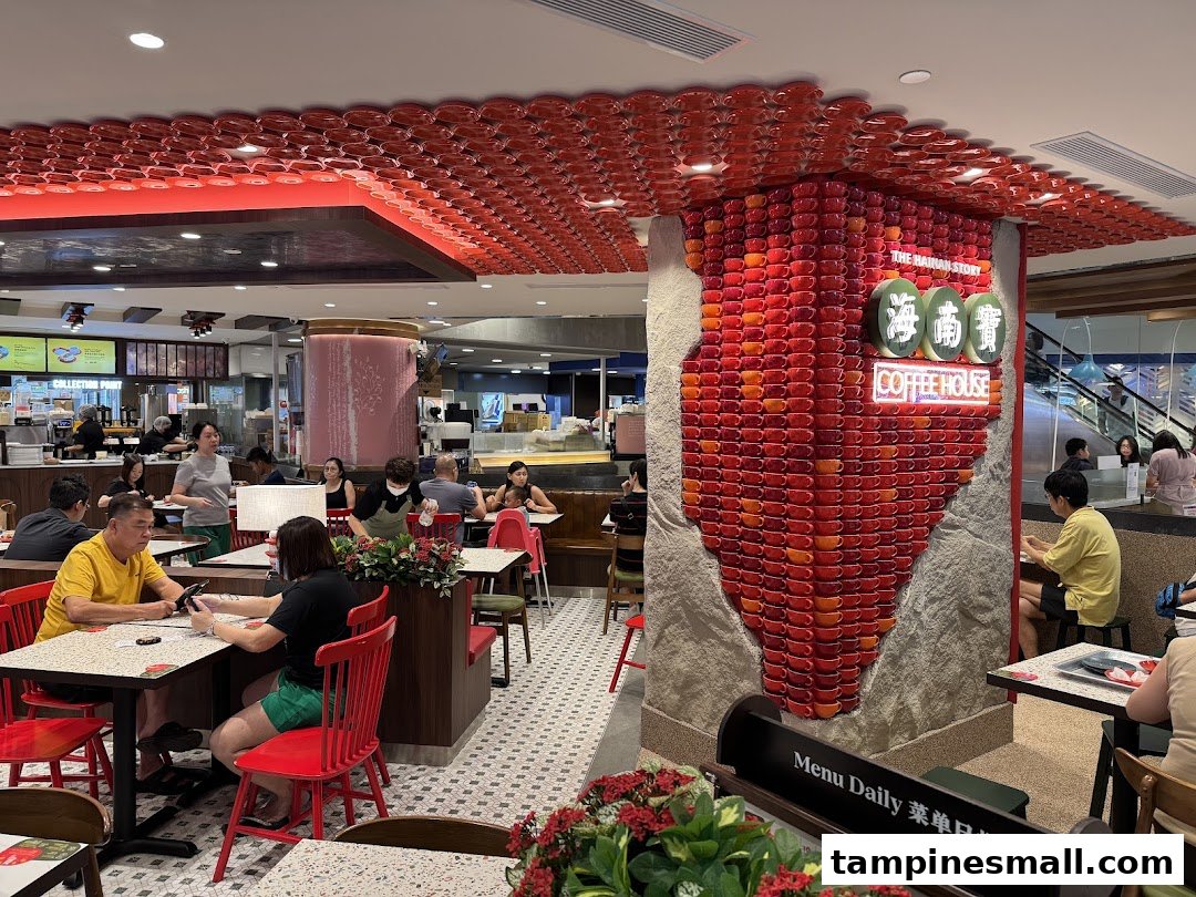 Interior view of The Hainan Story Coffee House, showcasing its unique red cup decor and bustling customer area.