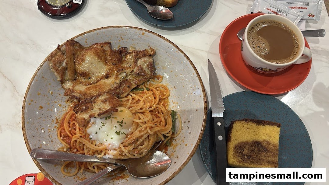 A delicious meal featuring spaghetti with grilled chicken, a poached egg, cake, and coffee.