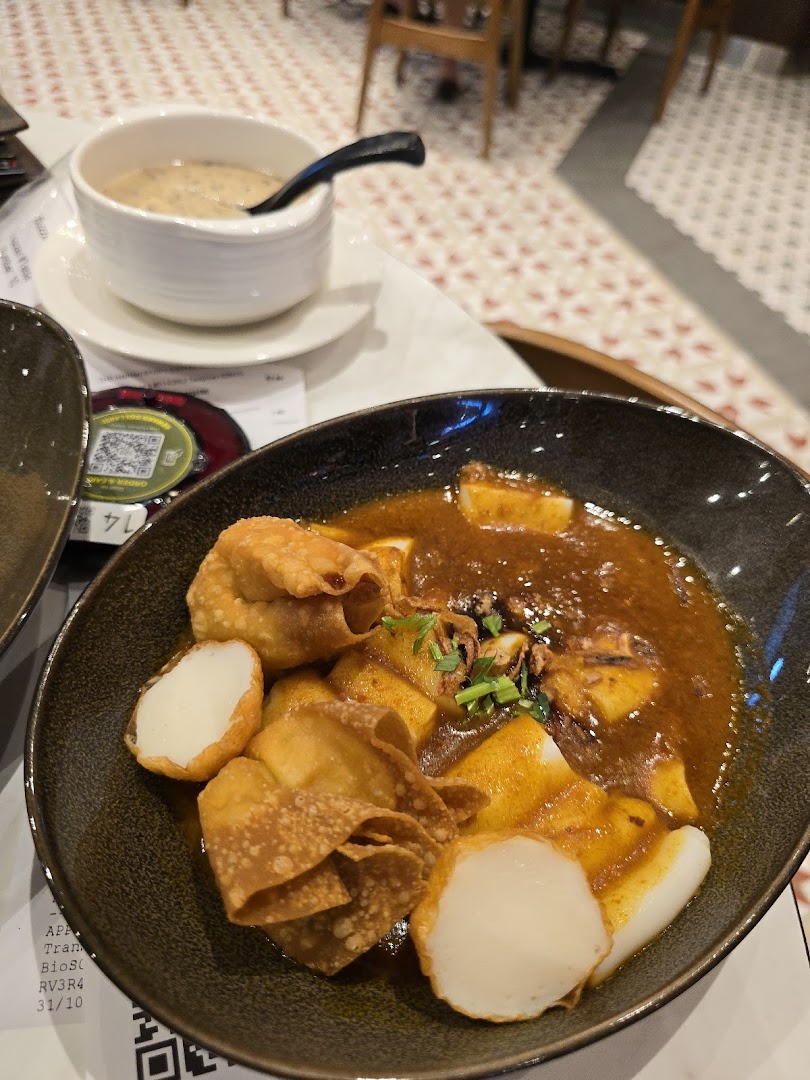 A close-up of delicious Hainanese dishes, featuring a main course with fried wontons and fish cakes, and a side soup.