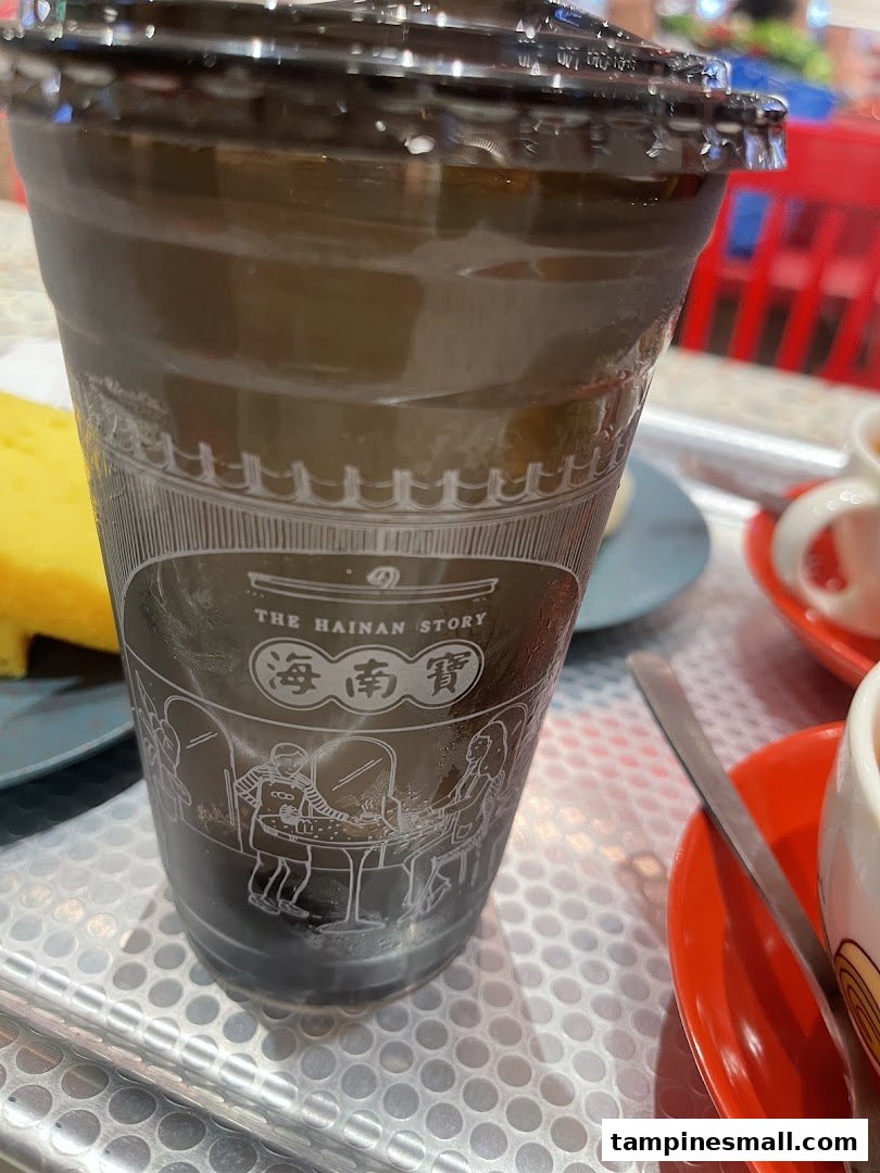 A branded cold beverage cup from The Hainan Story Coffee House, featuring its distinctive logo and design.